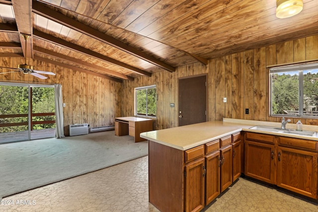 kitchen featuring beamed ceiling, wood ceiling, kitchen peninsula, and ceiling fan