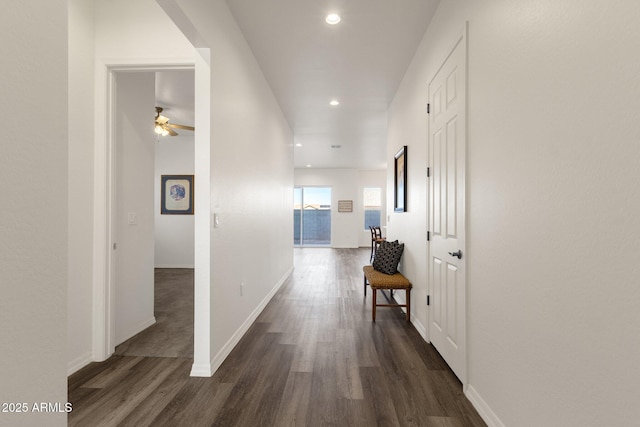 hallway with recessed lighting, baseboards, and dark wood-type flooring