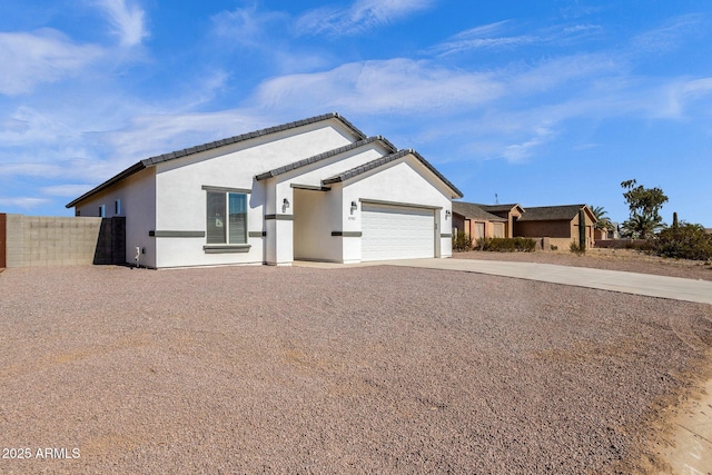 single story home with stucco siding, concrete driveway, a garage, and fence