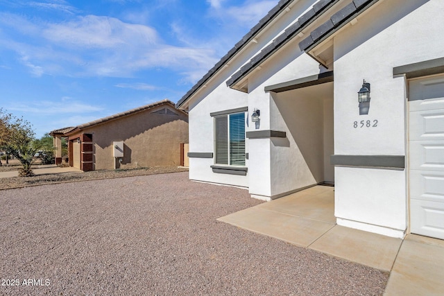 exterior space featuring stucco siding and a garage