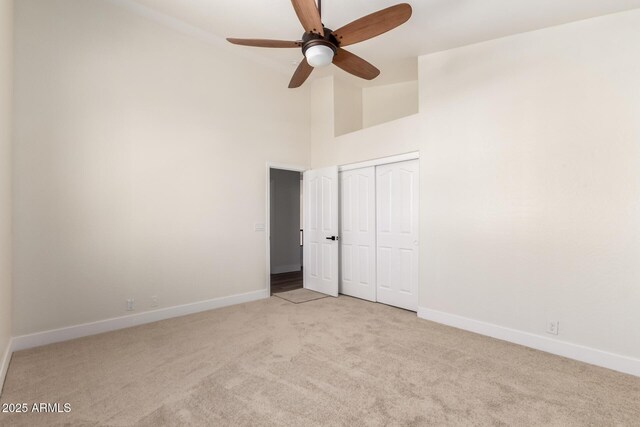 7179 W Surrey Ave, Peoria, AZ 85381 - unfurnished bedroom featuring light carpet, baseboards, high vaulted ceiling, a closet, and ceiling fan