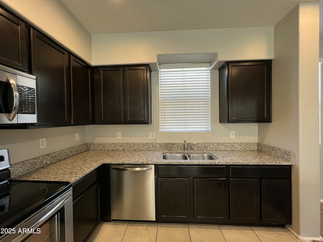 kitchen with light countertops, appliances with stainless steel finishes, a sink, and dark brown cabinets