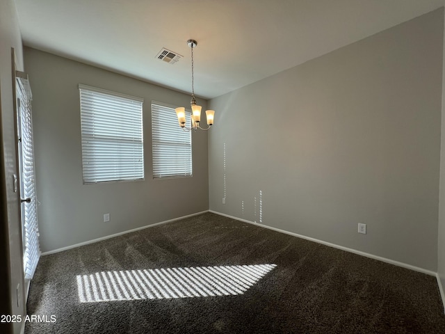 carpeted spare room with baseboards, visible vents, and an inviting chandelier