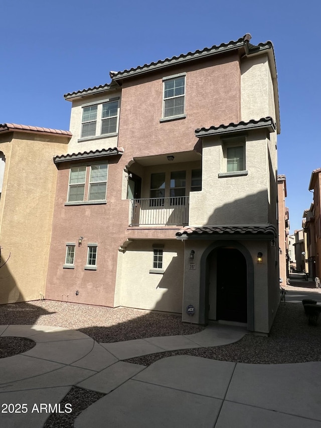 exterior space with a tiled roof and stucco siding