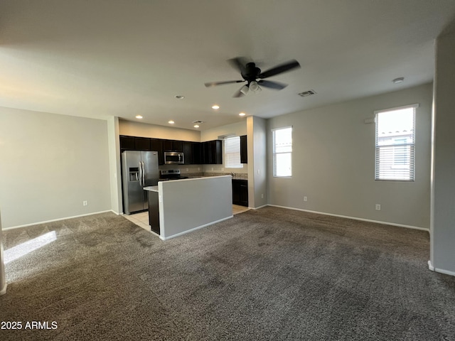 kitchen featuring stainless steel appliances, light colored carpet, visible vents, open floor plan, and a kitchen island