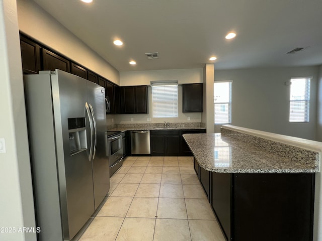 kitchen with light tile patterned floors, stainless steel appliances, recessed lighting, visible vents, and a sink