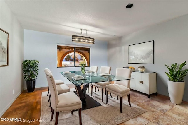 dining space featuring baseboards and a notable chandelier