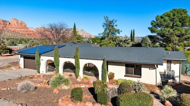 view of front of property featuring driveway, a garage, a mountain view, and stucco siding