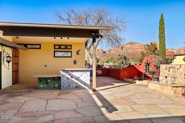 view of patio / terrace featuring fence and a mountain view