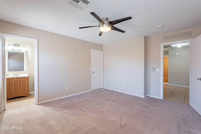 645 W Kingman Loop, Casa Grande, AZ 85122 - unfurnished bedroom featuring light colored carpet, baseboards, ensuite bathroom, and light tile patterned flooring