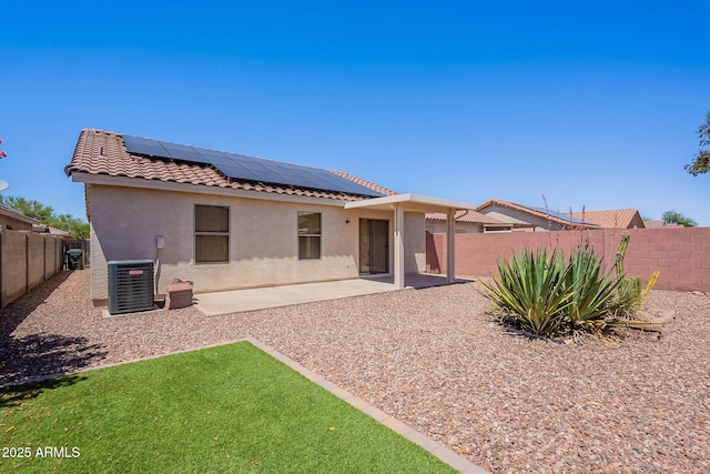 645 W Kingman Loop, Casa Grande, AZ 85122 - back of property featuring central AC, a tile roof, stucco siding, a fenced backyard, and solar panels