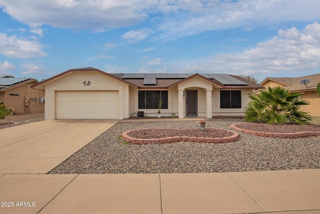 ranch-style home featuring an attached garage, concrete driveway, stucco siding, and solar panels