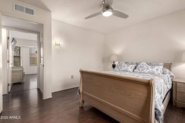 bedroom with visible vents, baseboards, and dark wood finished floors