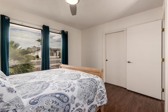 bedroom with a closet, a ceiling fan, and dark wood-style floors
