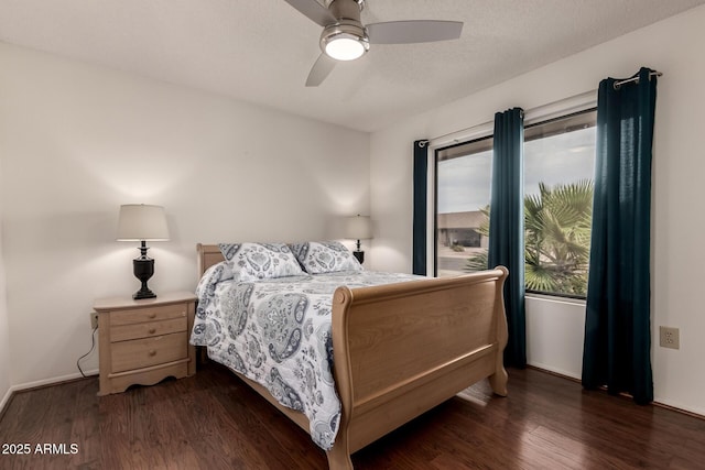 bedroom featuring dark wood-style floors, baseboards, and a ceiling fan
