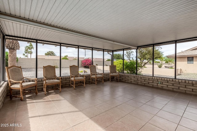 sunroom with tile patterned floors, a wealth of natural light, and a wall of windows