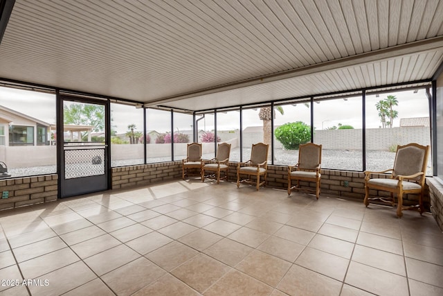 sunroom featuring tile patterned flooring, expansive windows, and a healthy amount of sunlight