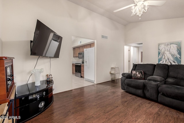 living area with light wood finished floors, visible vents, vaulted ceiling, and ceiling fan