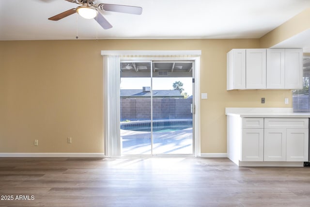 interior space featuring white cabinetry, light hardwood / wood-style flooring, and ceiling fan