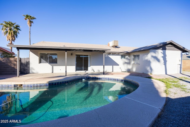 rear view of house featuring a fenced in pool and a patio area