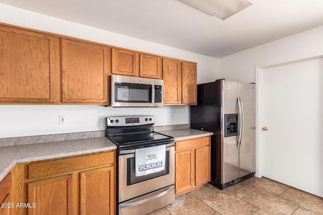 6085 S Wilson Dr, Chandler, AZ 85249 - kitchen featuring stainless steel appliances, brown cabinets, and light countertops