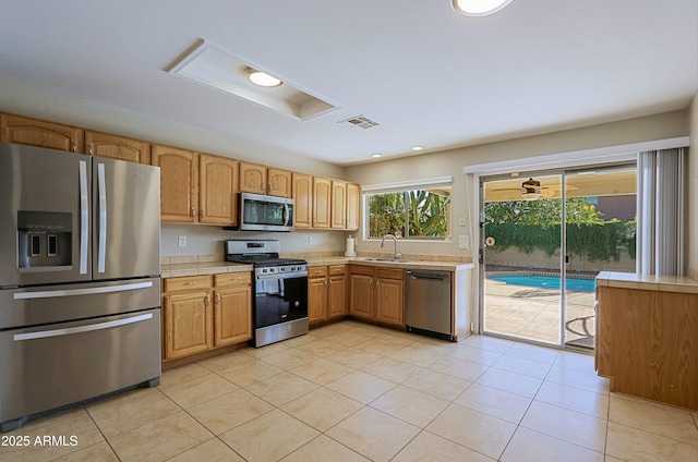 kitchen featuring light tile patterned flooring, sink, and stainless steel appliances