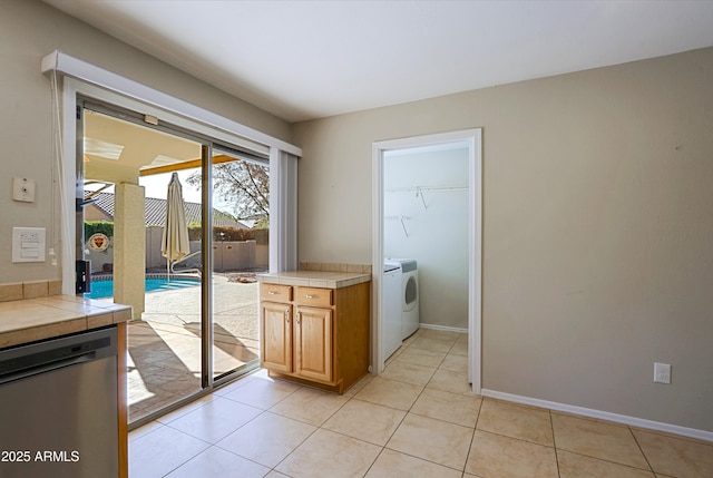 clothes washing area featuring separate washer and dryer and light tile patterned floors