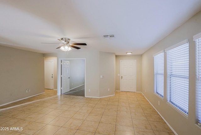 spare room featuring ceiling fan and light tile patterned floors