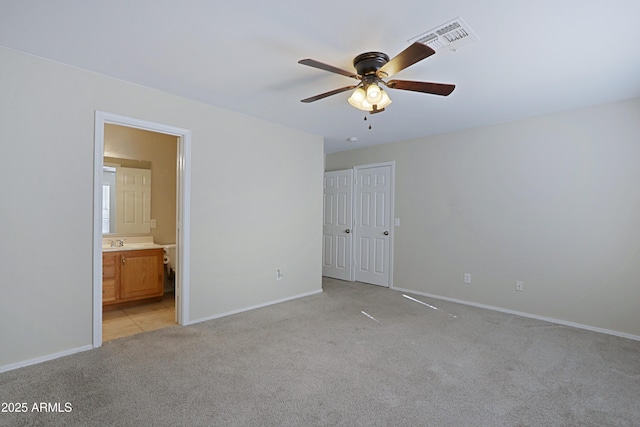 unfurnished bedroom with light carpet, sink, ceiling fan, connected bathroom, and a closet