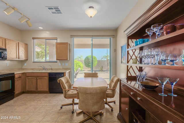 kitchen with rail lighting, light tile patterned floors, black appliances, and sink