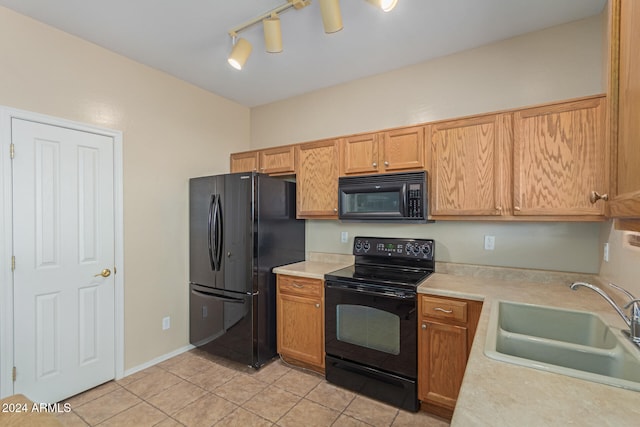 kitchen featuring sink, black appliances, rail lighting, and light tile patterned floors