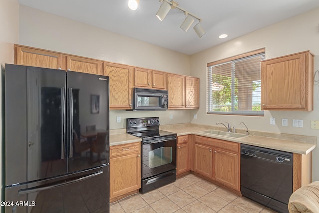 kitchen with black appliances, sink, and light tile patterned floors