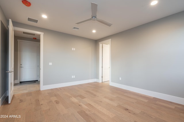 unfurnished room featuring baseboards, visible vents, light wood finished floors, and ceiling fan