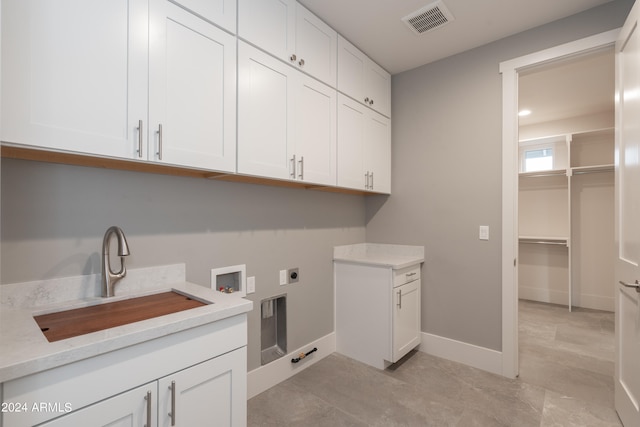 clothes washing area with light tile patterned floors, sink, cabinets, hookup for a washing machine, and electric dryer hookup