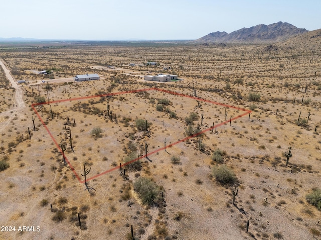 drone / aerial view featuring view of desert, a rural view, and a mountain view