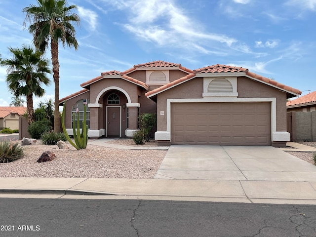 mediterranean / spanish-style home with a garage