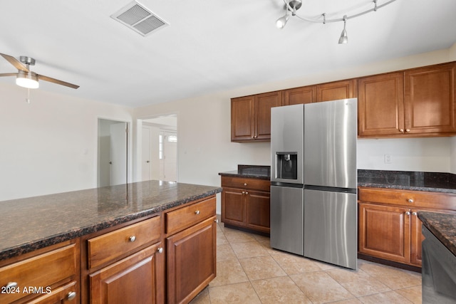 kitchen featuring light tile patterned floors, dark stone countertops, ceiling fan, and stainless steel appliances