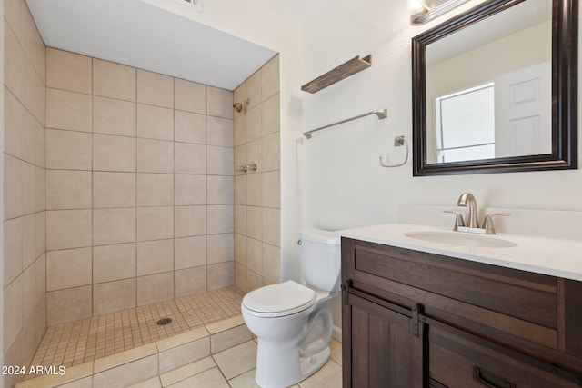 bathroom featuring a tile shower, vanity, toilet, and tile patterned floors