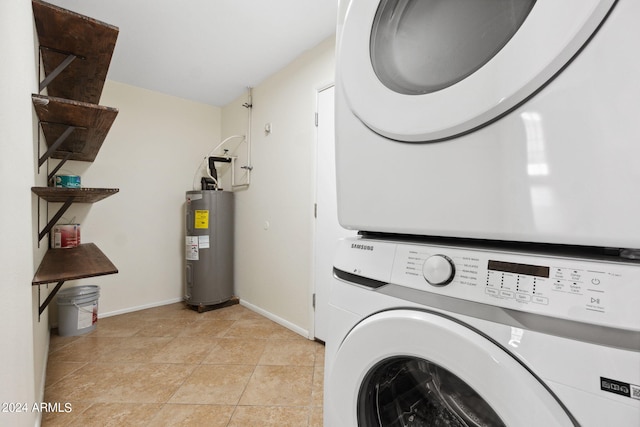 clothes washing area featuring water heater, stacked washer and dryer, and light tile patterned floors