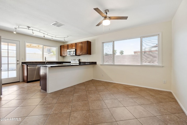 kitchen featuring stainless steel appliances, kitchen peninsula, light tile patterned flooring, and ceiling fan