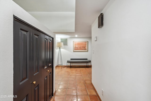 hallway featuring light tile patterned floors, visible vents, and baseboards
