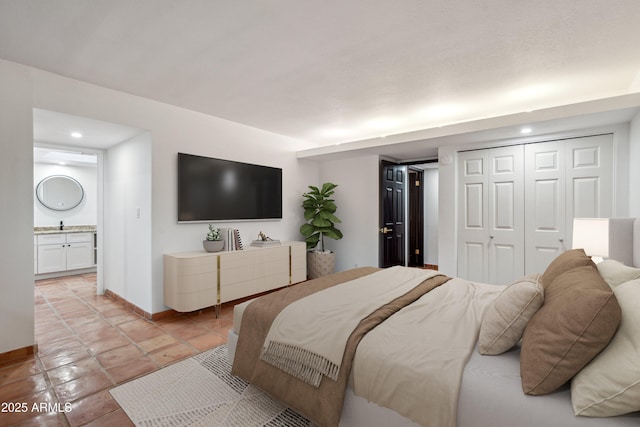 bedroom with light tile patterned floors, connected bathroom, a closet, recessed lighting, and baseboards