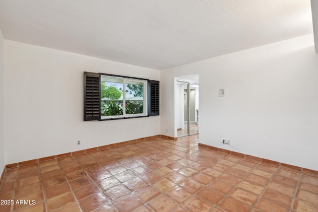 unfurnished room featuring baseboards