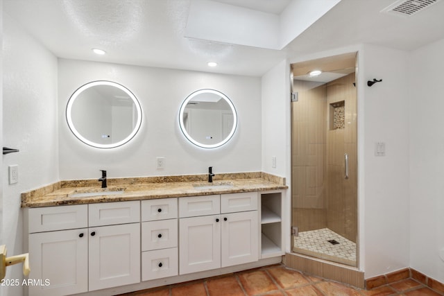 bathroom featuring a shower stall, double vanity, visible vents, and a sink