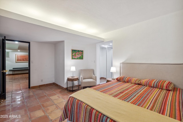 bedroom with light tile patterned floors and baseboards