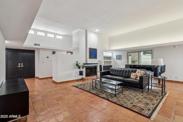 living room featuring visible vents, tile patterned floors, plenty of natural light, and baseboards