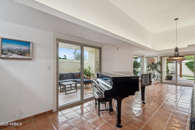 living area featuring baseboards, tile patterned flooring, and a healthy amount of sunlight