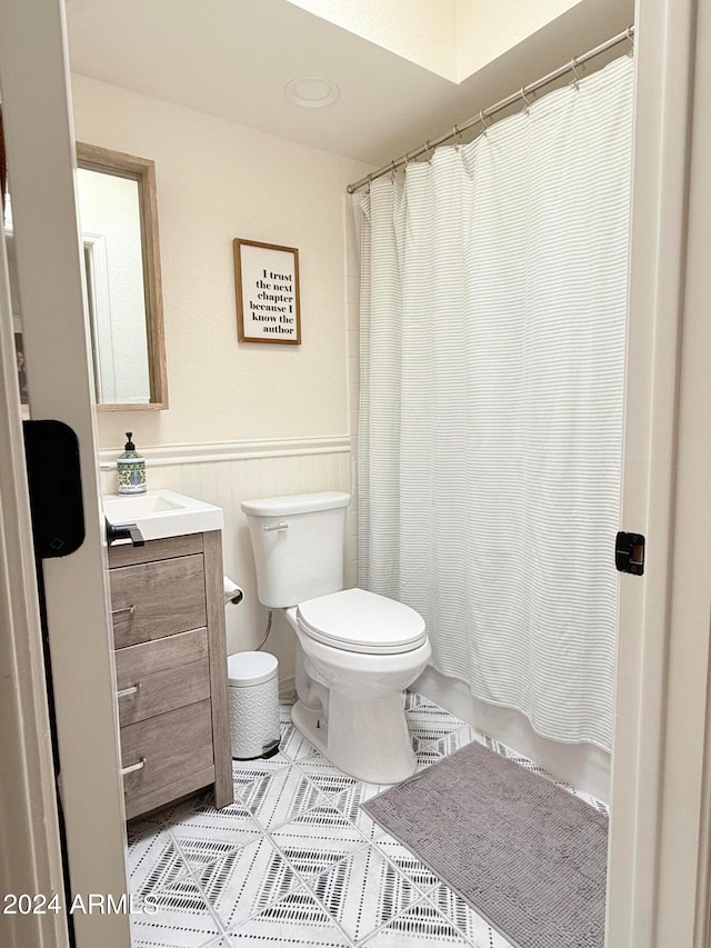 full bathroom featuring vanity, shower / tub combo with curtain, toilet, and tile patterned flooring