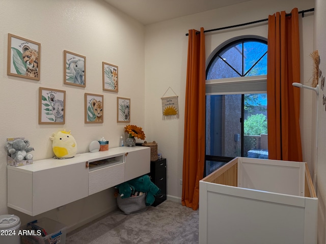 bedroom featuring light carpet, multiple windows, and a crib