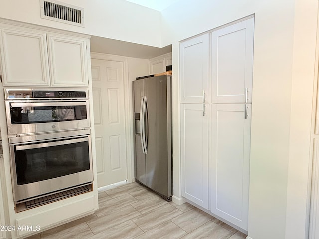 kitchen featuring light hardwood / wood-style floors, white cabinets, and stainless steel appliances